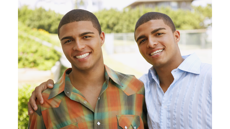 Hispanic twin brothers hugging