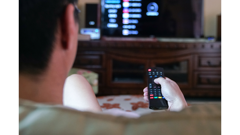 Man using remote control to watch TV