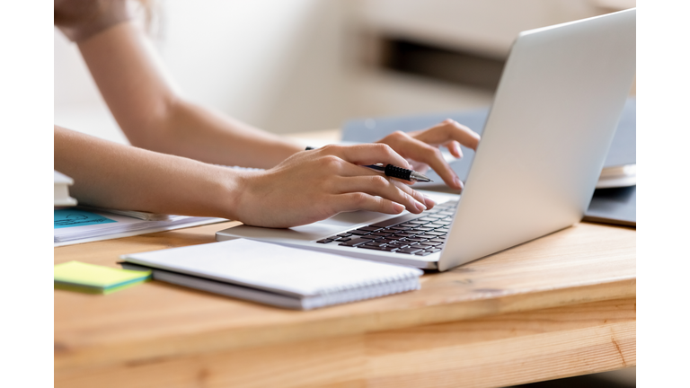 Closeup cropped image student girl hands typing using laptop