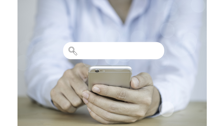 Midsection Of Woman Using Mobile Phone With Search Engine Symbol