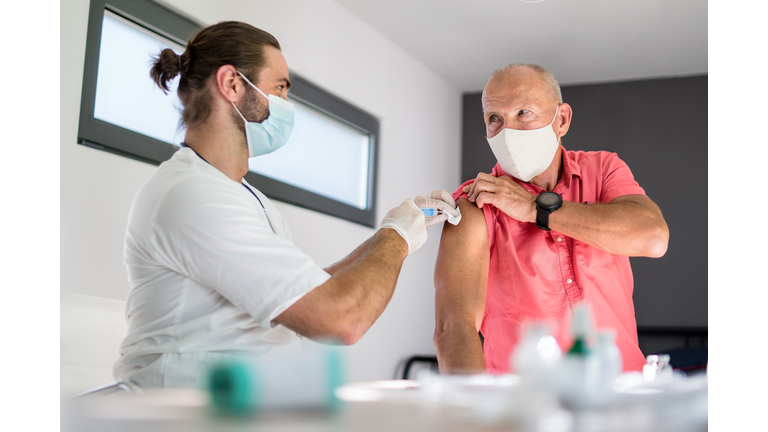 Senior man with face mask getting vaccinated