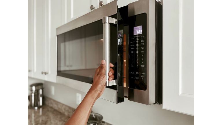 Close-Up of Woman Opening Microwave