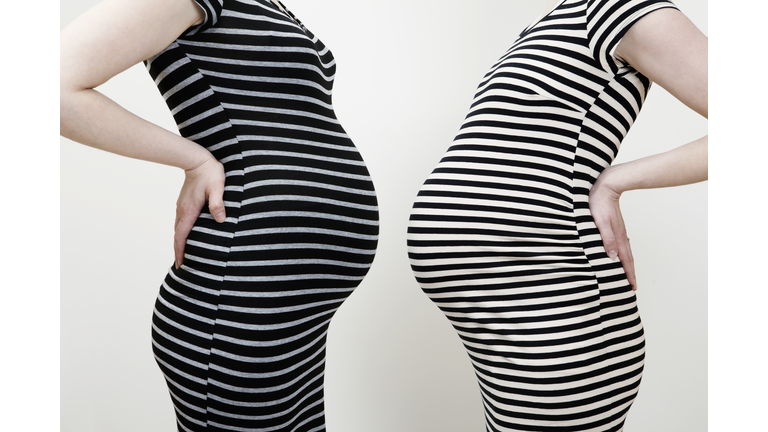 Two pregnant women in striped dresses