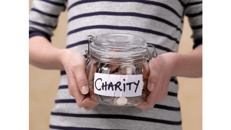 10 year old holding charity donations in a jar