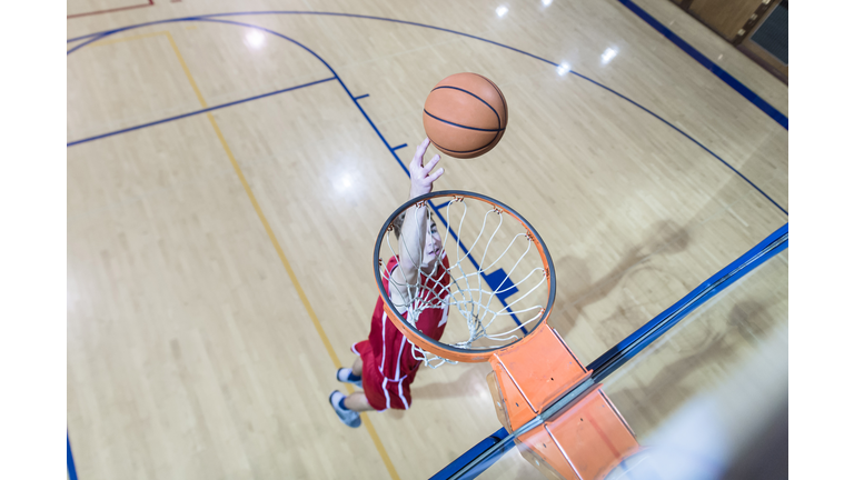 Overhead view of high school basketball player leaping to the basket