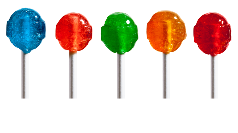 Row of Five Multicolored Hard Candy Lollipops Isolated on White