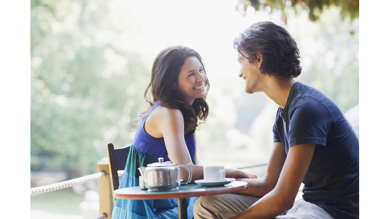 Smiling couple having tea outdoors