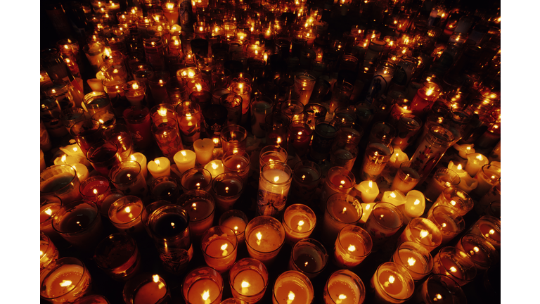 A close-up of multiple candles in a vigil