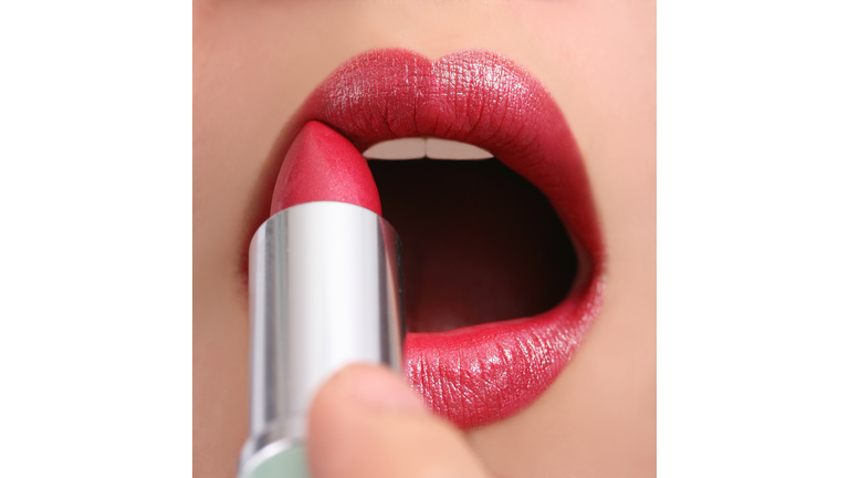 Close-up of person applying red lipstick