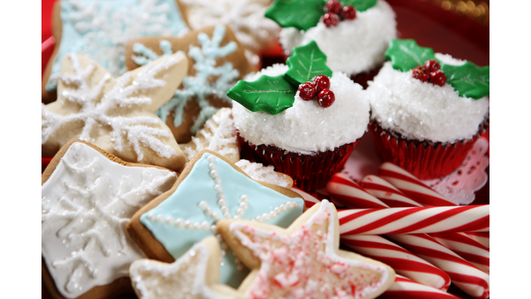 A plate of Christmas cookies, cupcakes and candy canes