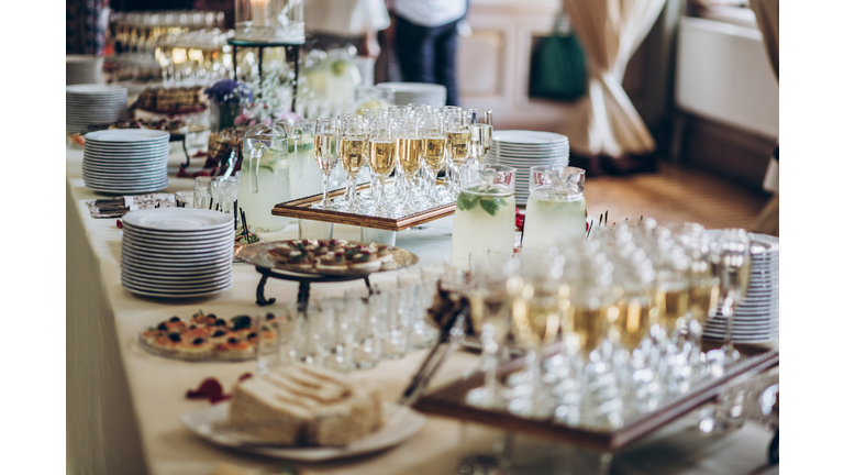 stylish champagne glasses and food  appetizers on table at wedding reception. luxury catering at celebrations. serving food and drinks at events concept