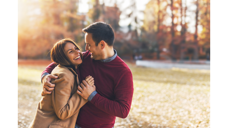 Happy couple at public park in autumn