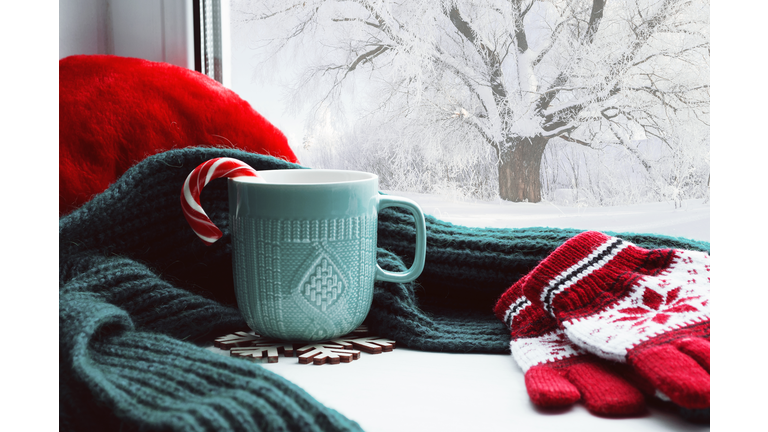 Winter background - cup, candy cane, woolen scarf and gloves