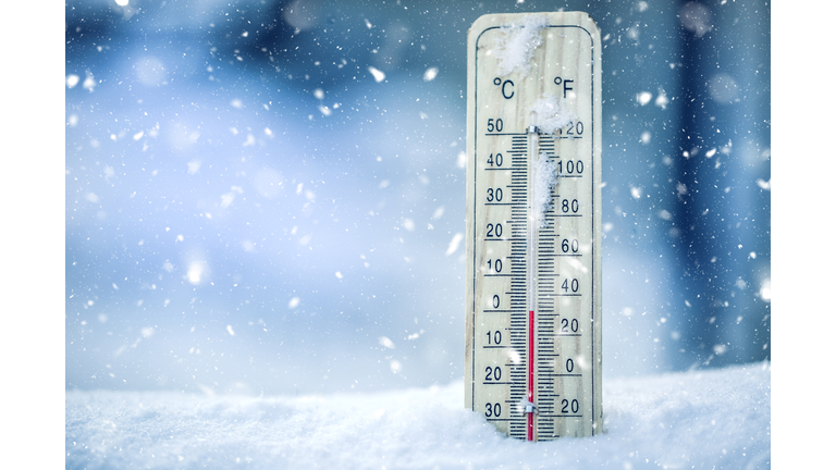 Thermometer on snow shows low temperatures - zero. Low temperatures in degrees Celsius and fahrenheit. Cold winter weather - zero celsius thirty two farenheit