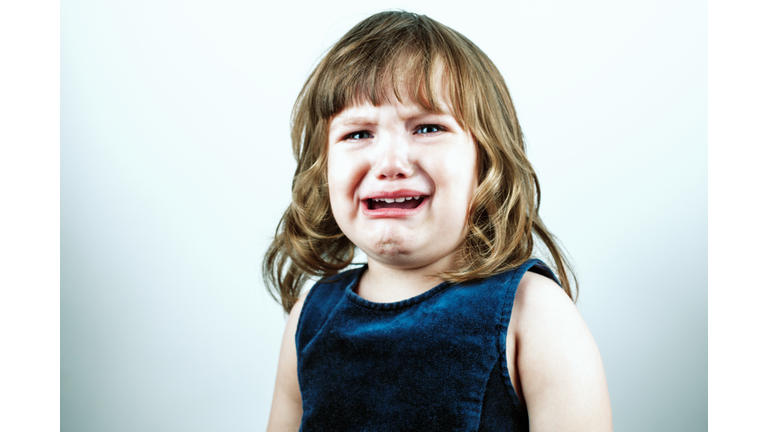 Crying toddler girl's studio portrait