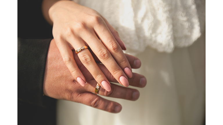 The bride and groom holding hands. Wedding theme. Close up.