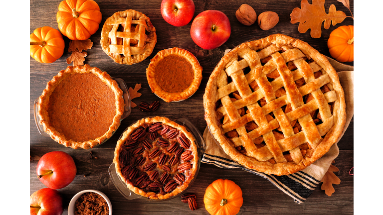 Variety of homemade autumn pies. Apple, pumpkin and pecan. Table scene over rustic wood.