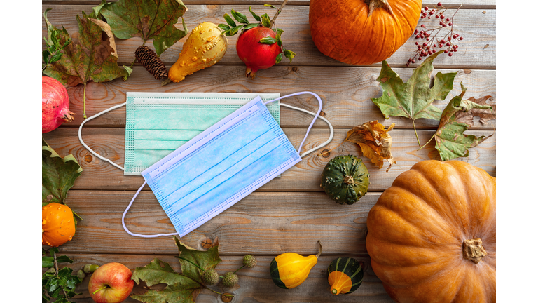 Protective mask and thanksgiving pumpkins against wooden background