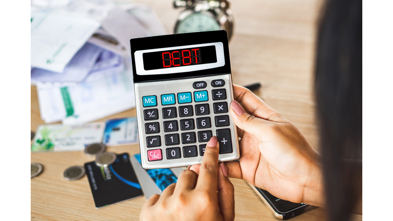 Woman Hand Calculating Her Expenses With Unpaid Financial Bills ,Credit Cards On Desk