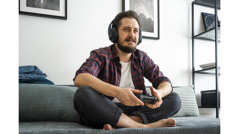 Man sitting on couch and playing video game