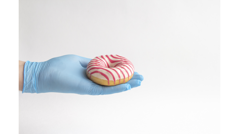 Donut on hand in blue glove