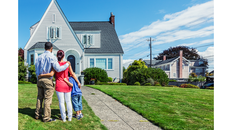 Happy Young Family Admiring Home