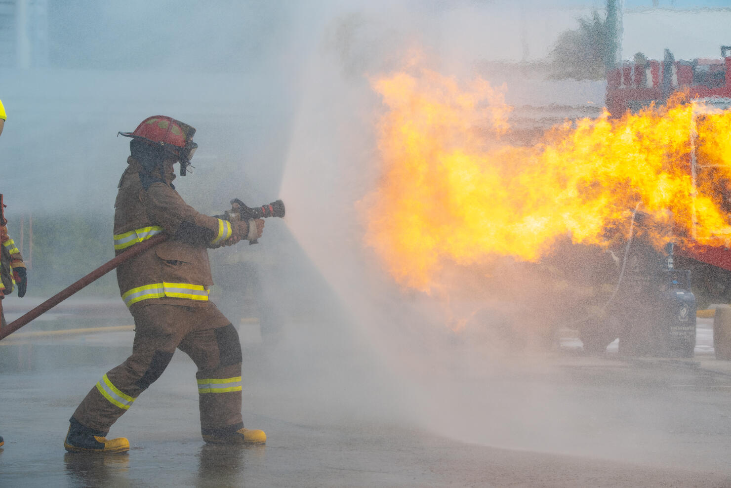 Firefighter spraying water at a house fire