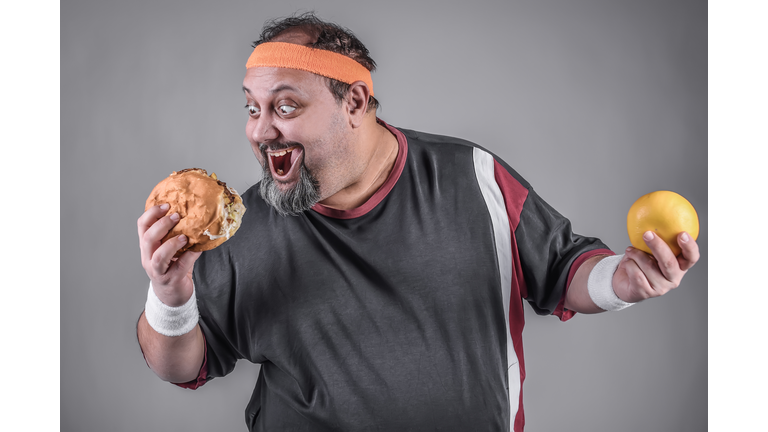 Hungry Big mouth can't adore to eat his burger while on dieting