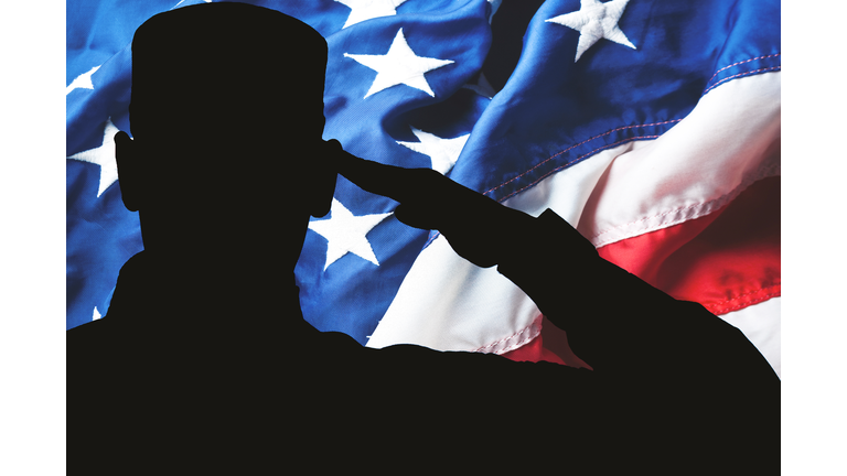 Proud saluting male army soldier on american flag background