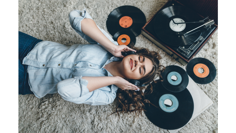 Young woman enjoing music from gramophone