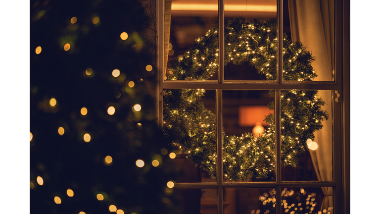 View through a window of a Christmas wreath in a living room