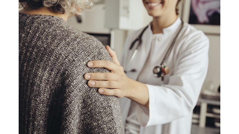 Doctor soothing senior patient