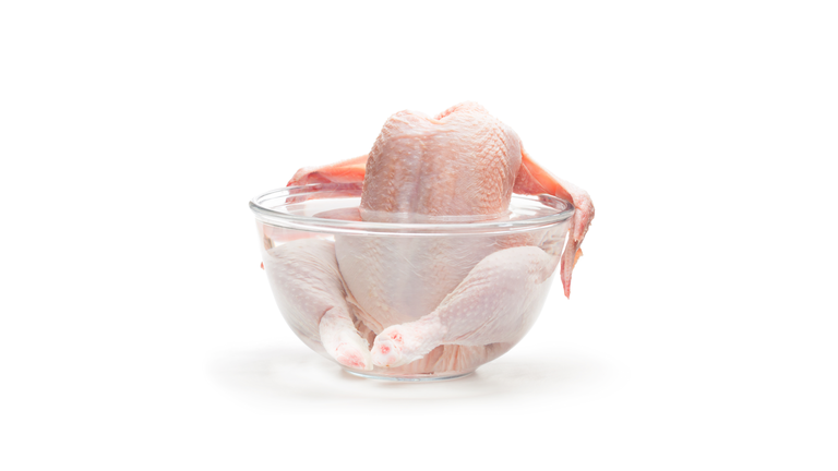 Raw  chicken in the water isolated on white background. Ready for cooking.
