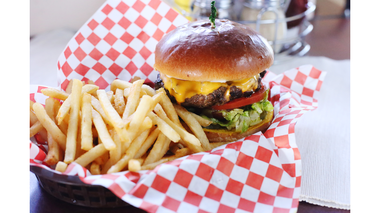 High angle view of burger with French fries served on table in restaurant