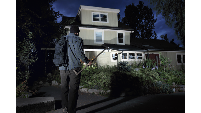 Burglar approaching a home at night