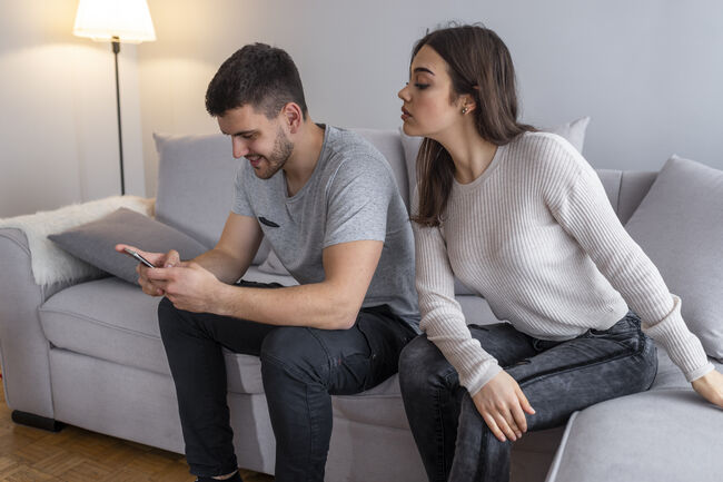 Jealous suspicious mad wife arguing with obsessed husband holding phone texting cheating on cellphone