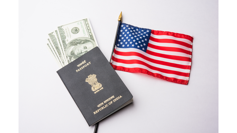 concept showing Indian passport with US currency notes or Dollars with american flag in the background, applying for US / american tourist or H-1B visa or travel visa