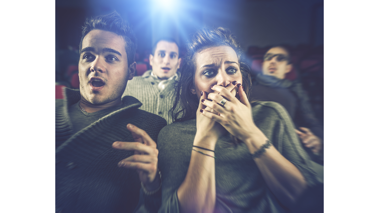 Couple scared at the cinema, watching horror movie