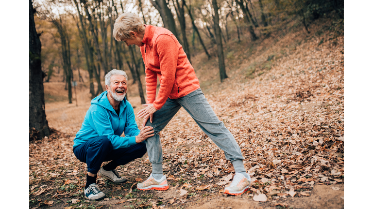 Senior couple exercising calf stretch in a park