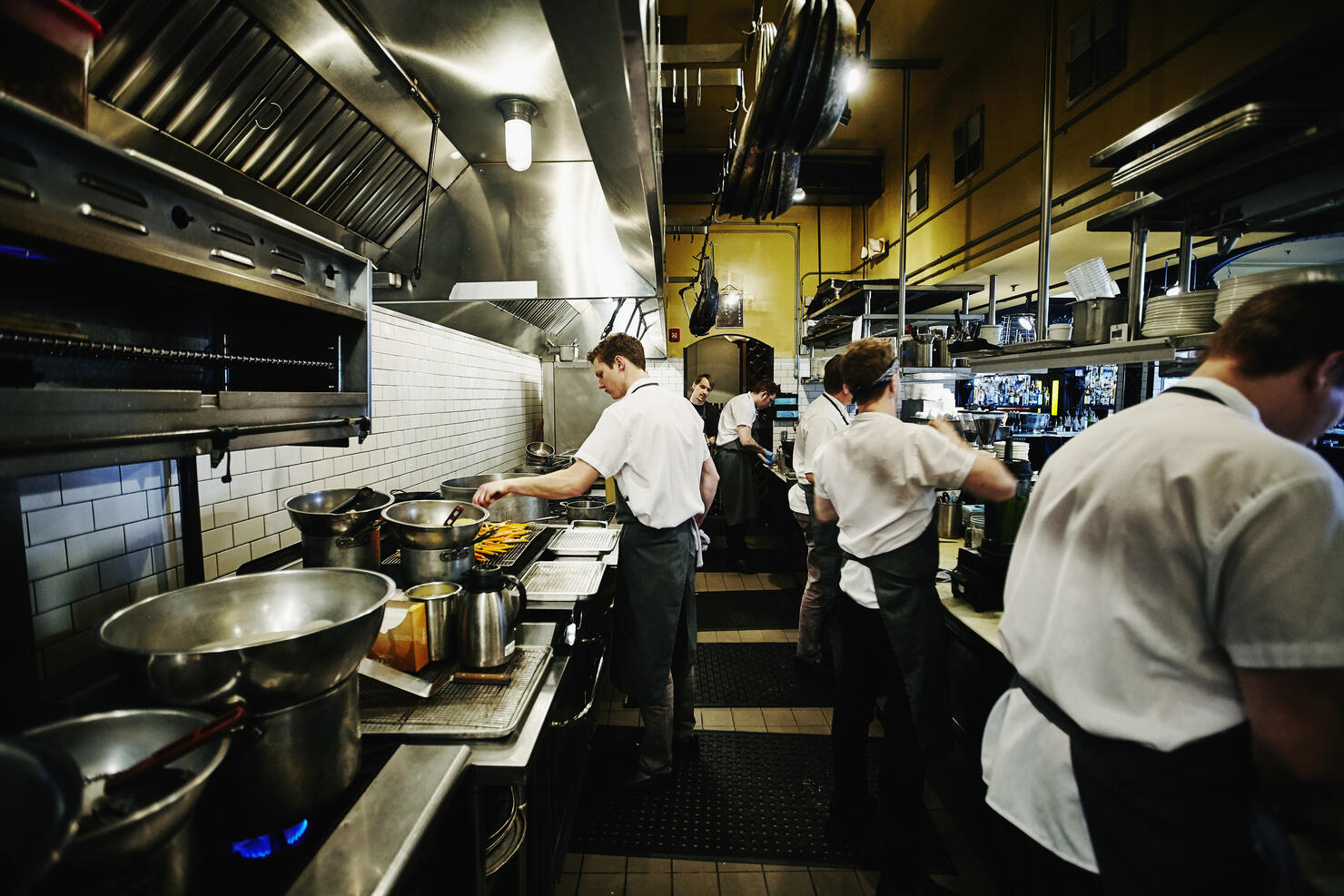 Chef and kitchen staff preparing dinner in kitchen