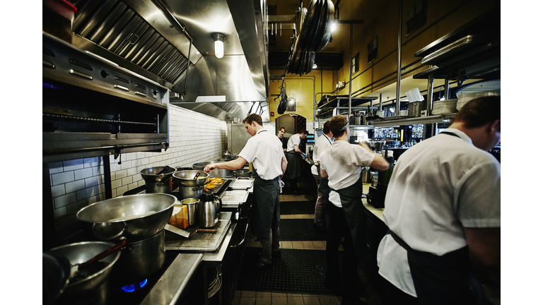 Chef and kitchen staff preparing dinner in kitchen