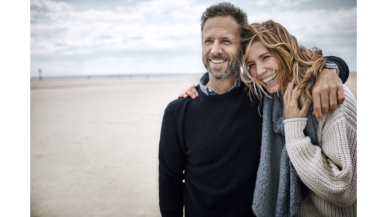 Happy couple hugging on the beach