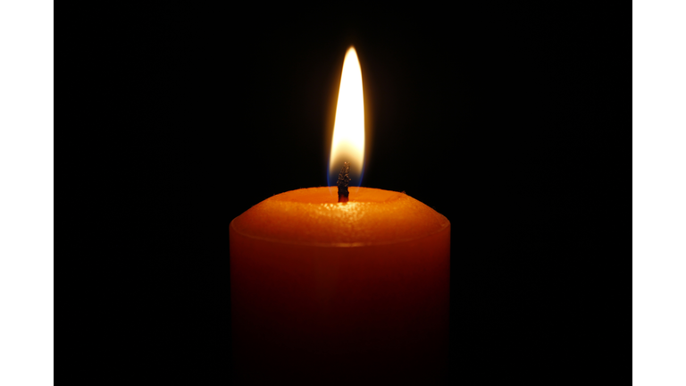 Close-Up Of Lit Candle Against Black Background