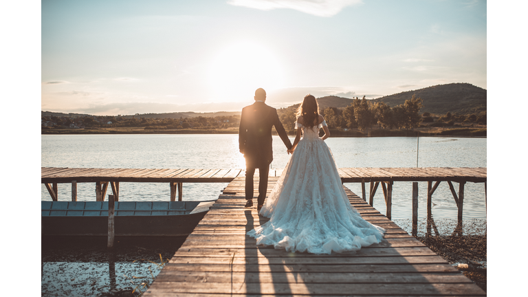 Happy couple by the lake in sunset