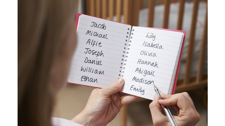 Woman Choosing Baby Names In Nursery