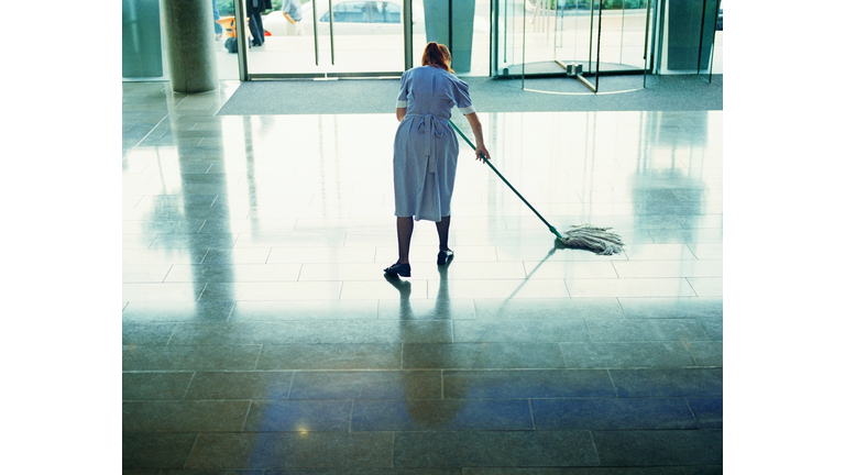 Maid mopping hotel lobby floor