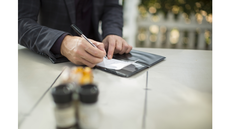 Businessman signing the bill at restaurant