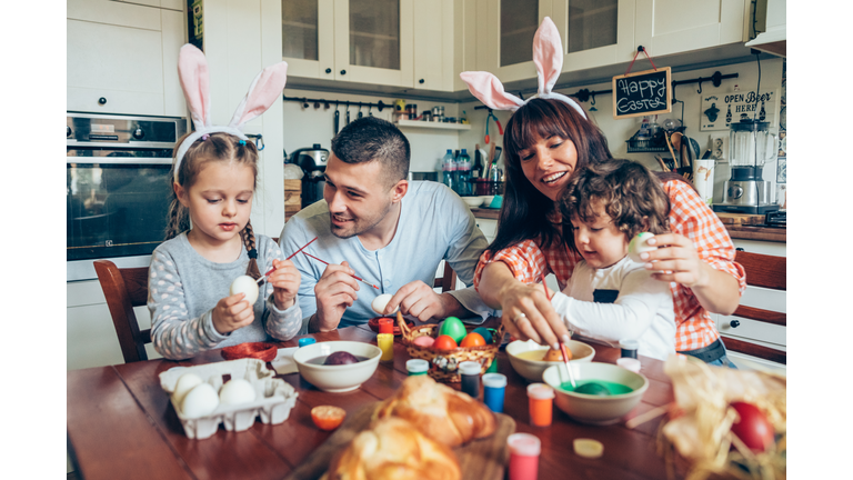 Happy family painting Easter eggs