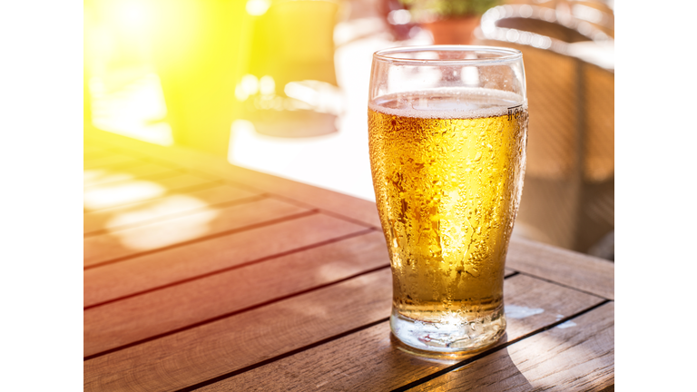 Glass of light beer on the wooden table.