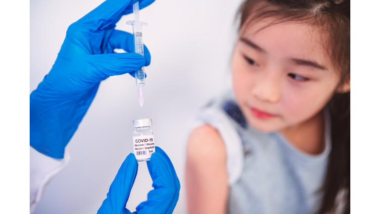 Kid girl is about to receive a COVID-19 vaccination shot